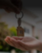 Photograph of someone holding a house key from buying real estate