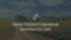 photograph of grasslands with a hill in the background and a dirt road