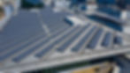 Photograph of solar panels on the rooftop of a warehouse building